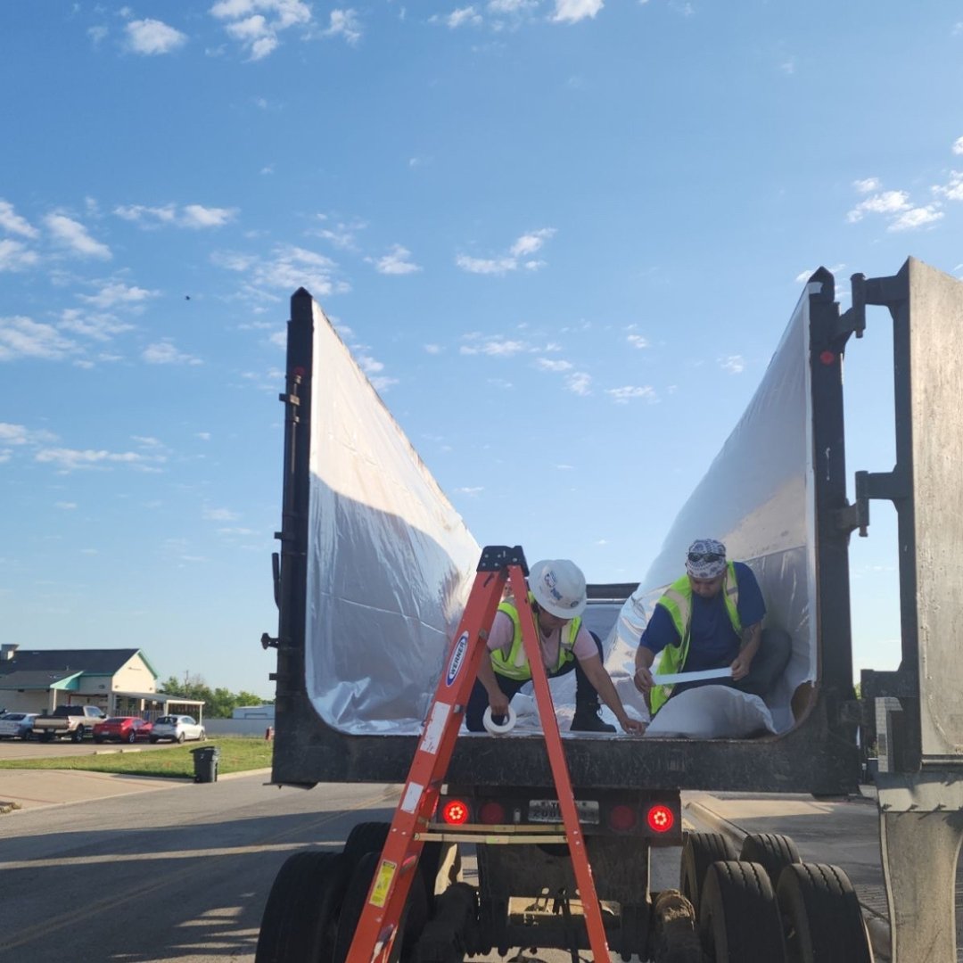 Image of CRC team working to place liner onto truck for transporting demolition materials 