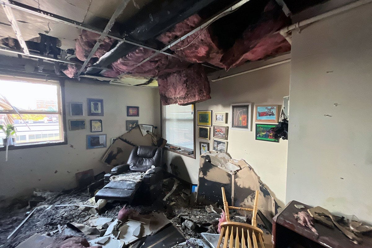 Insulation-hanging-from-ceiling-and-living-room-filled-with-burned-debris-after-fire