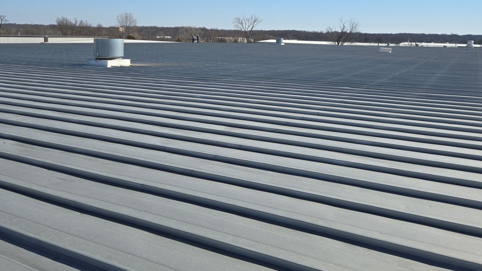 Metal roof of manufacturing facility dented from hail