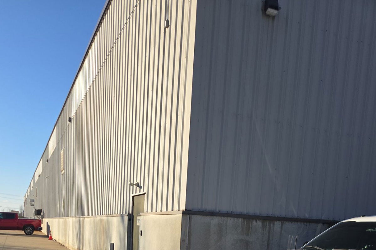 Metal siding on manufacturing plant damaged by hail