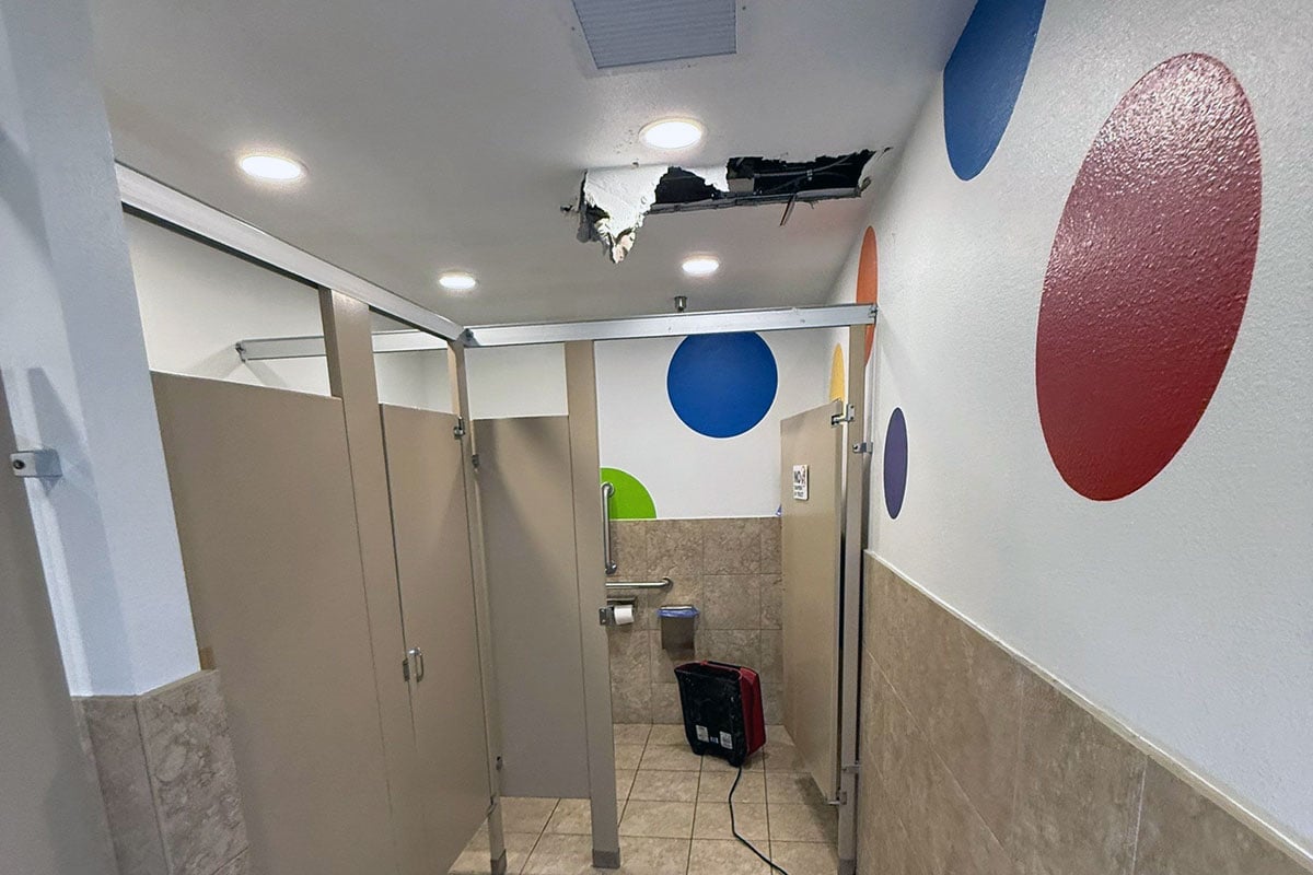 Drying equipment in bathroom that sustained water damage from fire suppression system putting out fire in indoor play place.