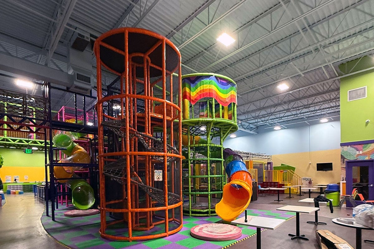 Indoor playground facility with play structure 16+ feet high.