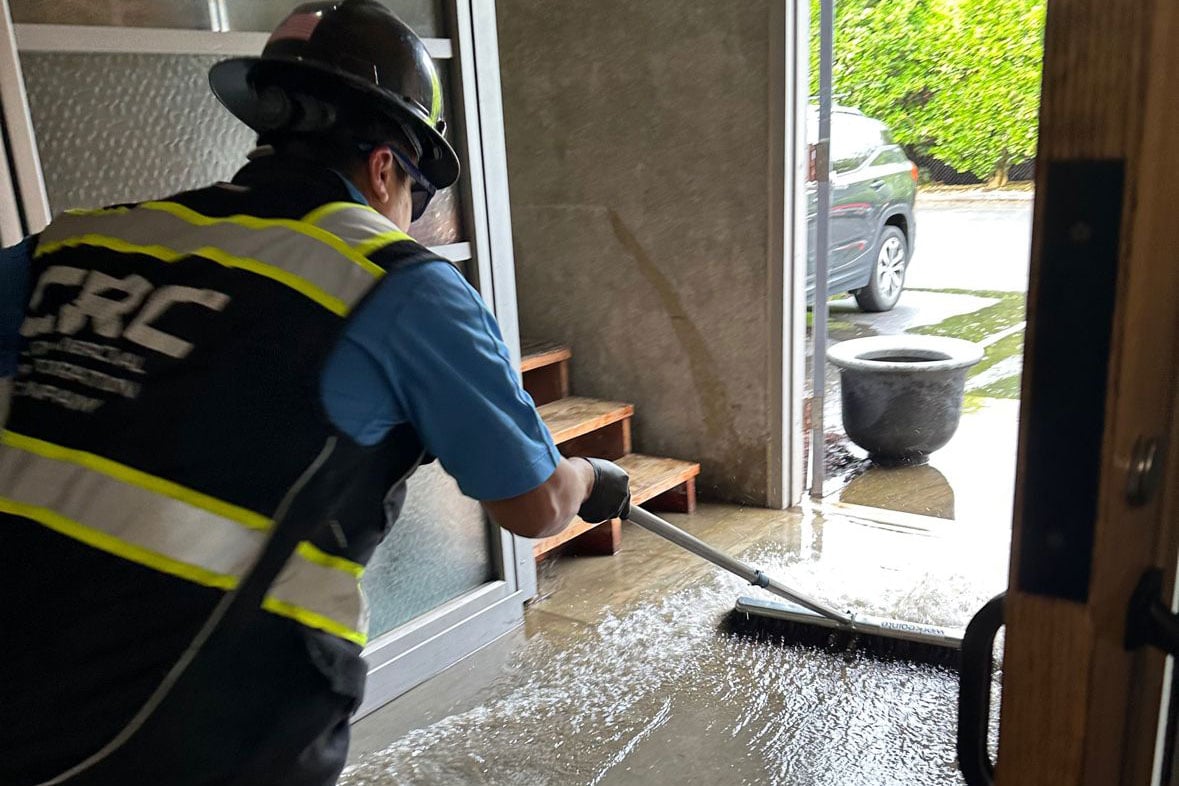 CRC employee removes water from the warehouse.